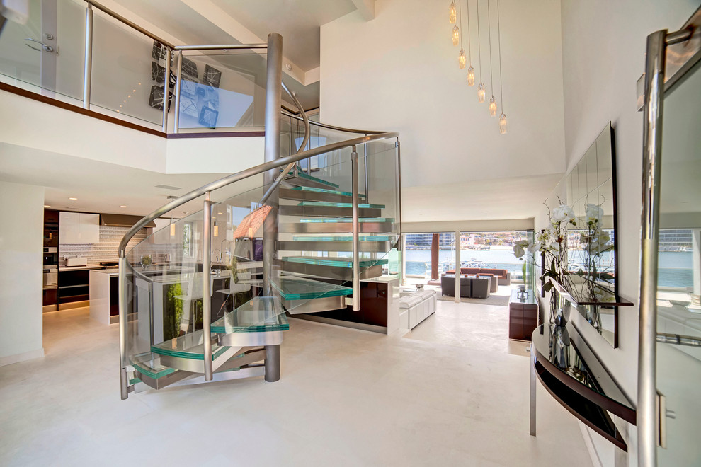 Design ideas for a contemporary glass spiral glass railing staircase in Orange County with open risers and feature lighting.