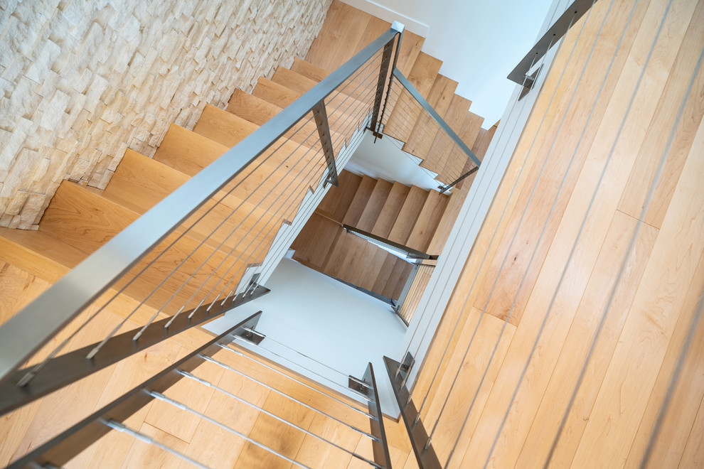 Источник вдохновения для домашнего уюта: огромная винтовая лестница в современном стиле с деревянными ступенями и металлическими перилами
