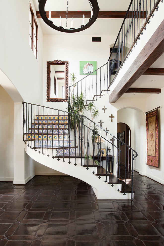 Inspiration pour un escalier courbe méditerranéen avec des marches en bois et des contremarches carrelées.