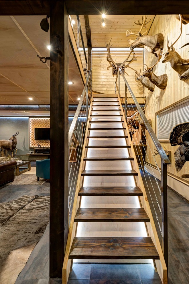 Ejemplo de escalera recta rural grande con escalones de madera, contrahuellas de madera y barandilla de metal