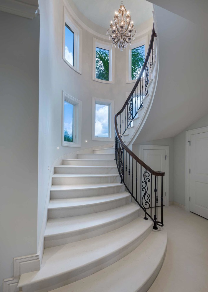 Photo of an expansive mediterranean curved mixed railing staircase in Other with travertine treads and travertine risers.