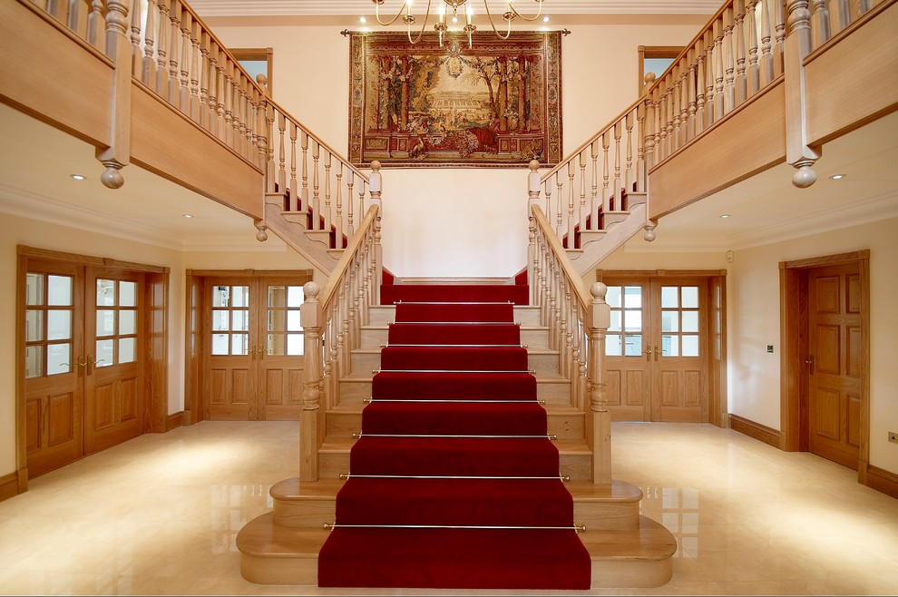 ロンドンにある高級な巨大なトラディショナルスタイルのおしゃれな直階段 (木の蹴込み板) の写真