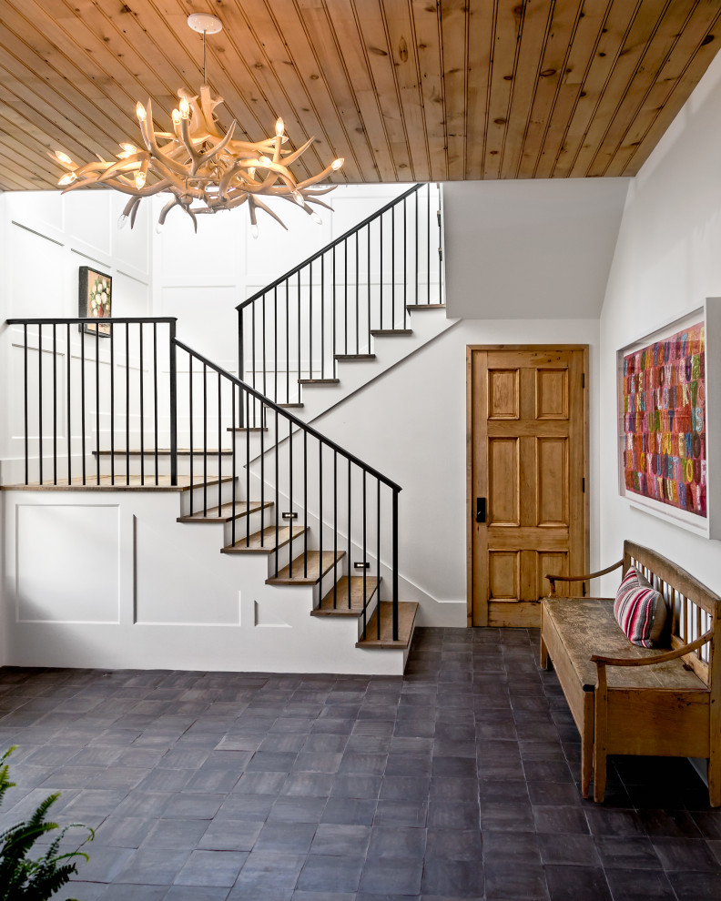 Design ideas for a large nautical wood u-shaped metal railing staircase in Los Angeles with wood risers and tongue and groove walls.