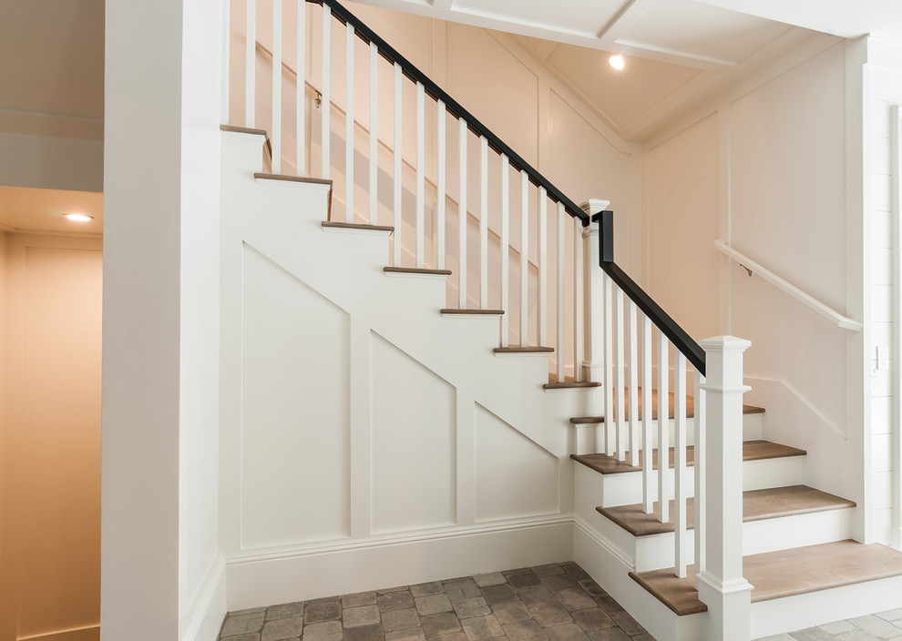 Imagen de escalera en L de estilo de casa de campo de tamaño medio con escalones de madera, barandilla de madera y contrahuellas de madera pintada