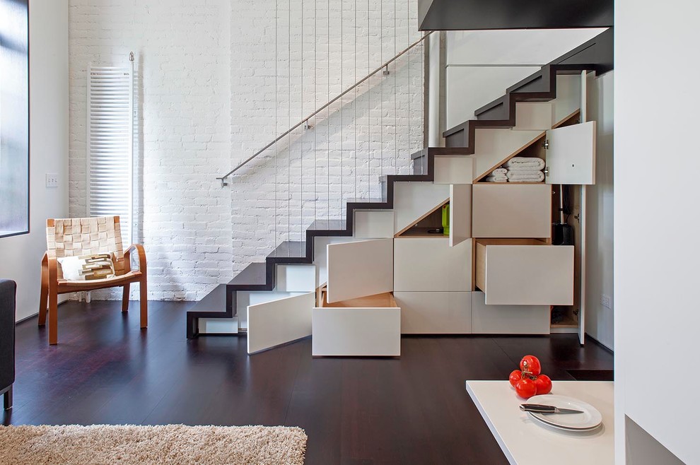 Photo of a small industrial wood straight staircase in New York with wood risers and under stair storage.