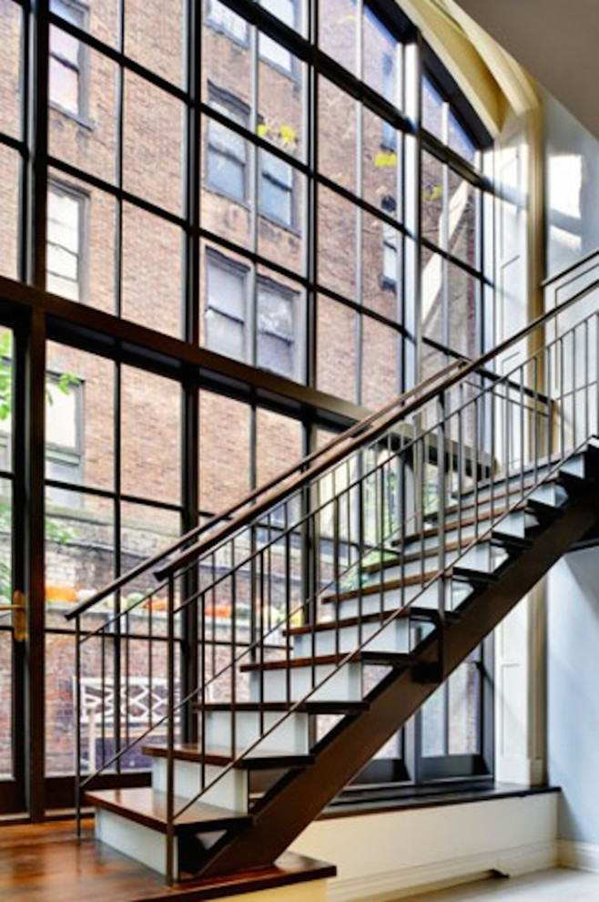 Aménagement d'un grand escalier droit industriel avec des marches en bois et des contremarches en bois.
