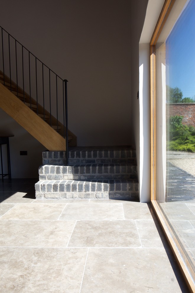 Foto de escalera en L de estilo de casa de campo de tamaño medio sin contrahuella con escalones de madera y barandilla de metal