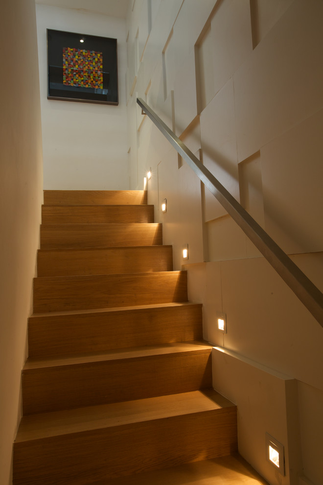 Inspiration for a mid-sized contemporary wooden u-shaped staircase remodel in London with wooden risers