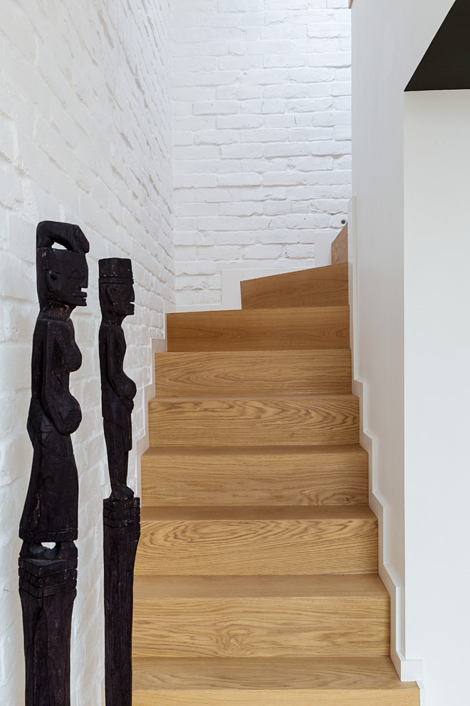 This is an example of a small industrial wood curved staircase in Moscow with wood risers.