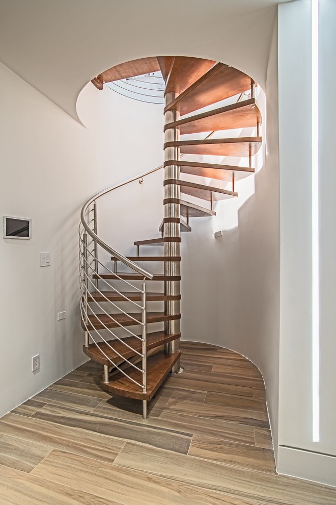 Immagine di una scala a chiocciola design di medie dimensioni con nessuna alzata, pedata in legno e parapetto in metallo