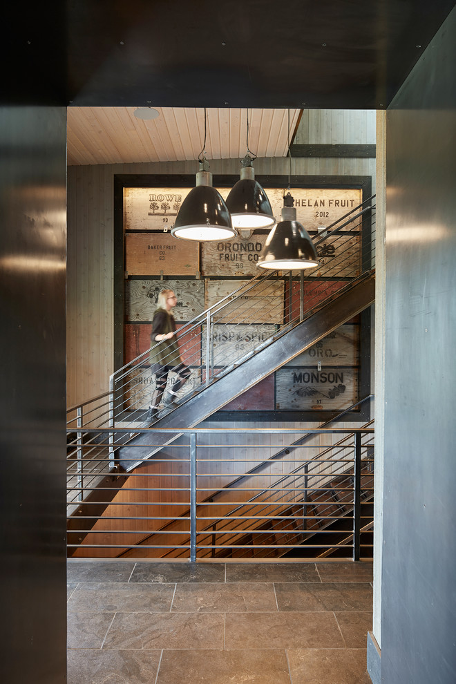 シアトルにある高級な中くらいなカントリー風のおしゃれな折り返し階段 (金属の蹴込み板、金属の手すり) の写真