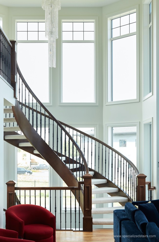 Exempel på en klassisk svängd trappa, med heltäckningsmatta, öppna sättsteg och räcke i flera material