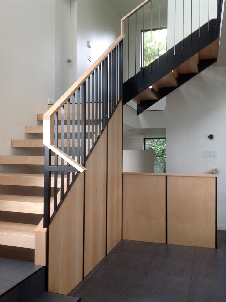 Пример оригинального дизайна: большая лестница на больцах в стиле модернизм с деревянными ступенями без подступенок