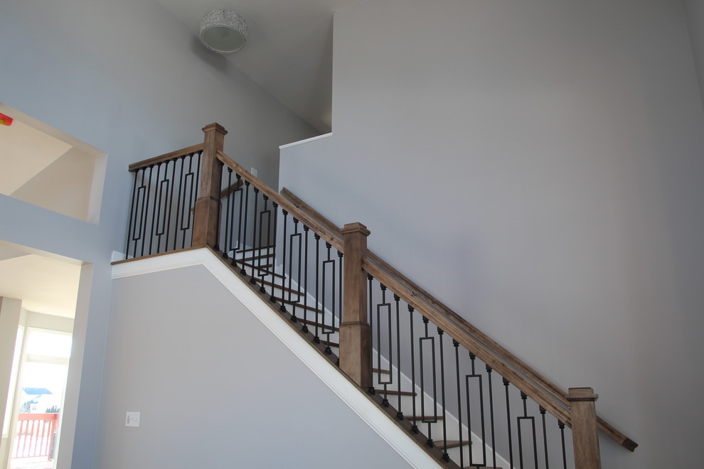 Cette image montre un escalier peint design en L de taille moyenne avec des marches en bois et un garde-corps en bois.