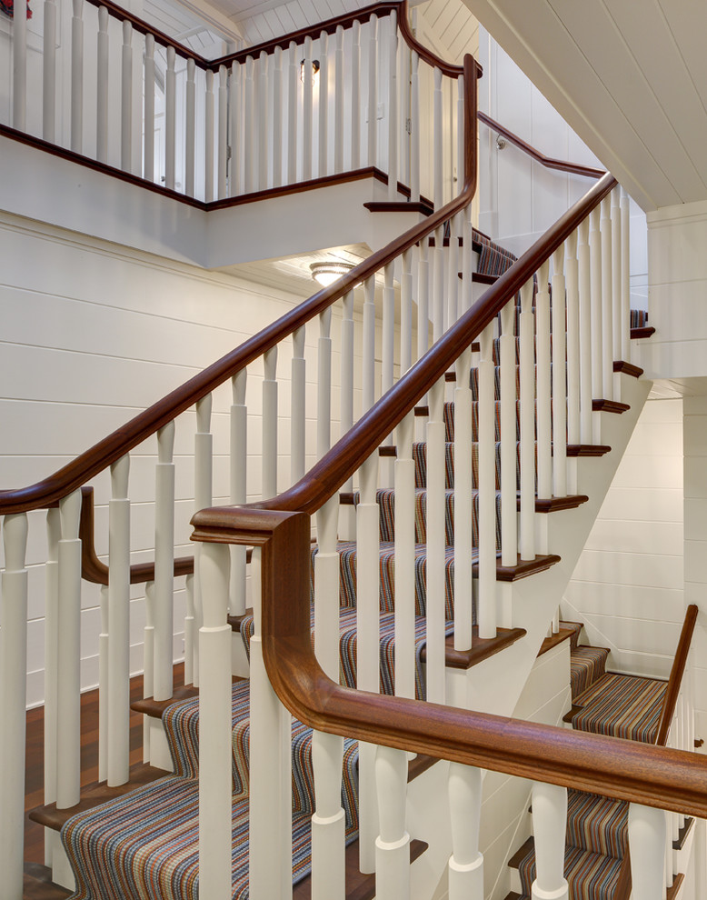 Photo of a beach style wood l-shaped staircase in Milwaukee with painted wood risers.