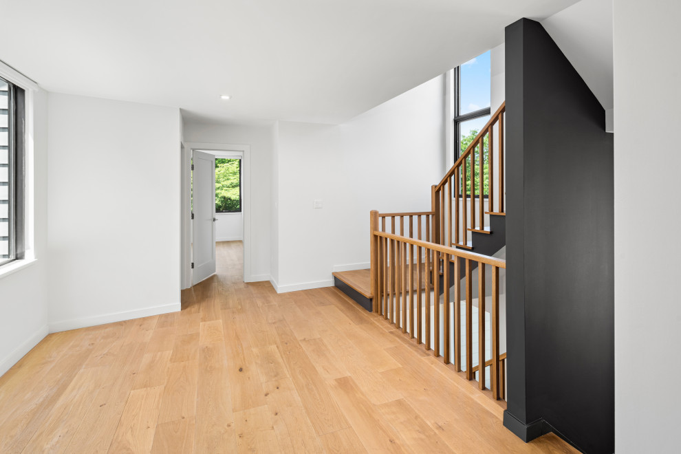 Imagen de escalera en U contemporánea de tamaño medio con escalones de madera, contrahuellas de madera pintada y barandilla de madera