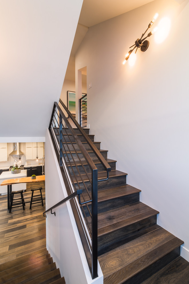 На фото: п-образная деревянная лестница среднего размера в стиле модернизм с деревянными ступенями и металлическими перилами с