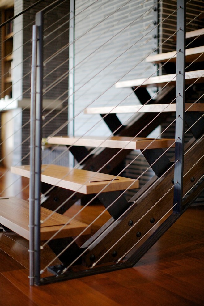 Diseño de escalera suspendida moderna grande sin contrahuella con escalones de madera
