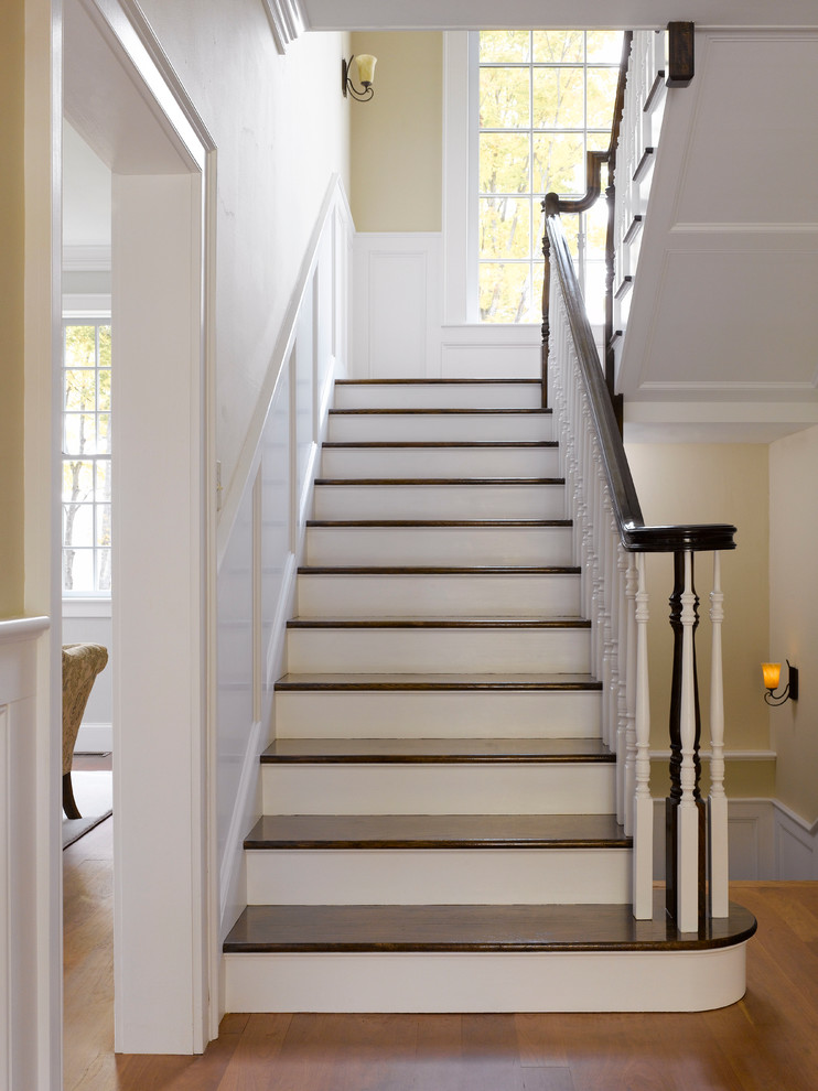 Cette image montre un escalier traditionnel en U avec des marches en bois et palier.