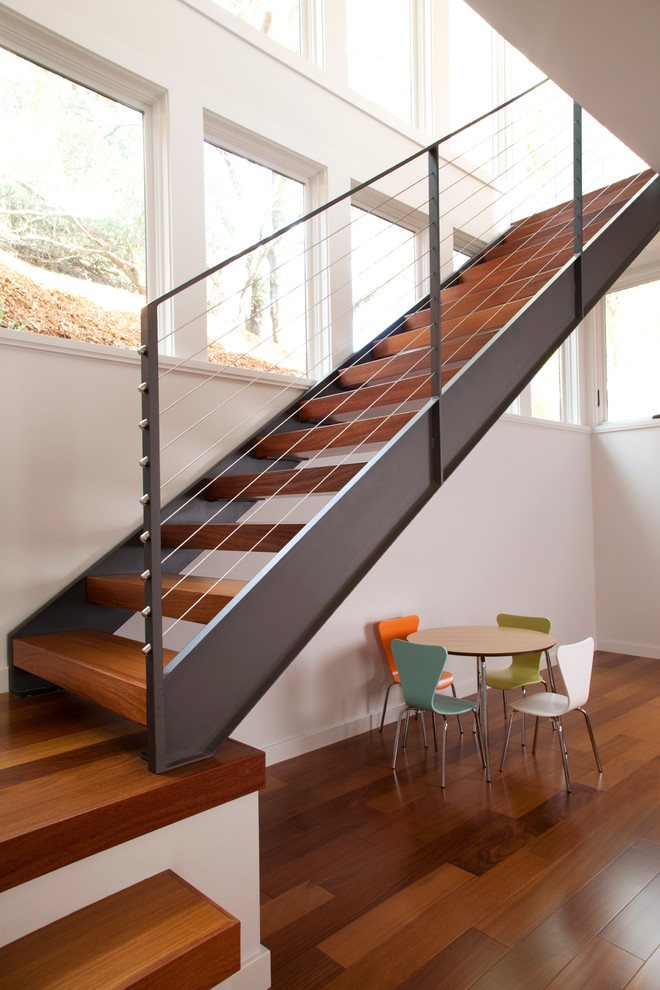 Idée de décoration pour un escalier sans contremarche design en L avec des marches en bois.