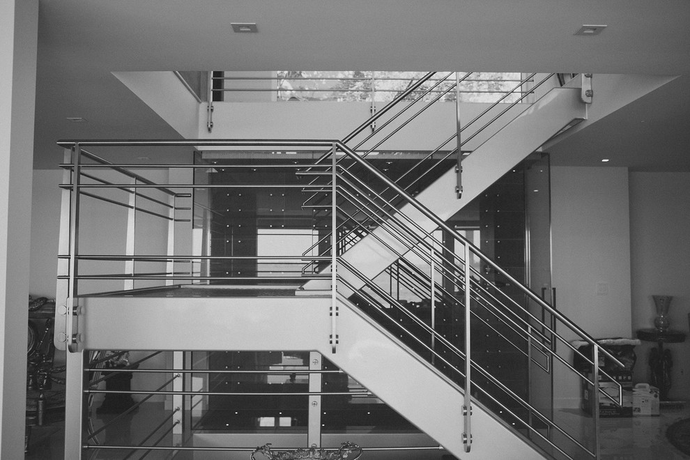 Réalisation d'un grand escalier sans contremarche urbain en U avec des marches en verre.