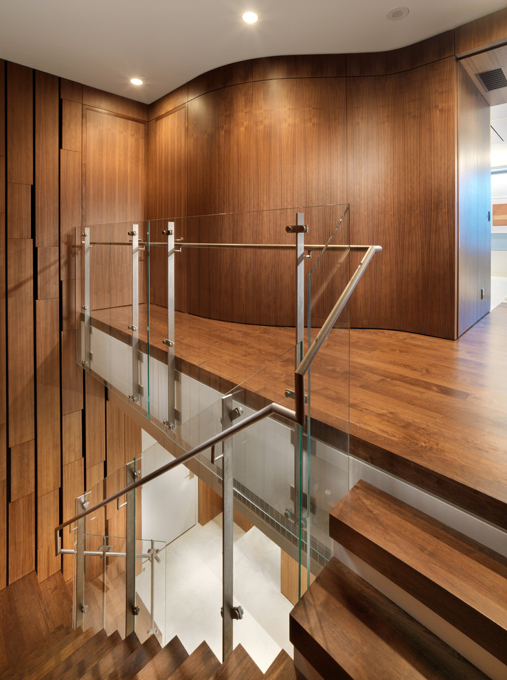 Пример оригинального дизайна: лестница в стиле модернизм с деревянными ступенями и стеклянными перилами