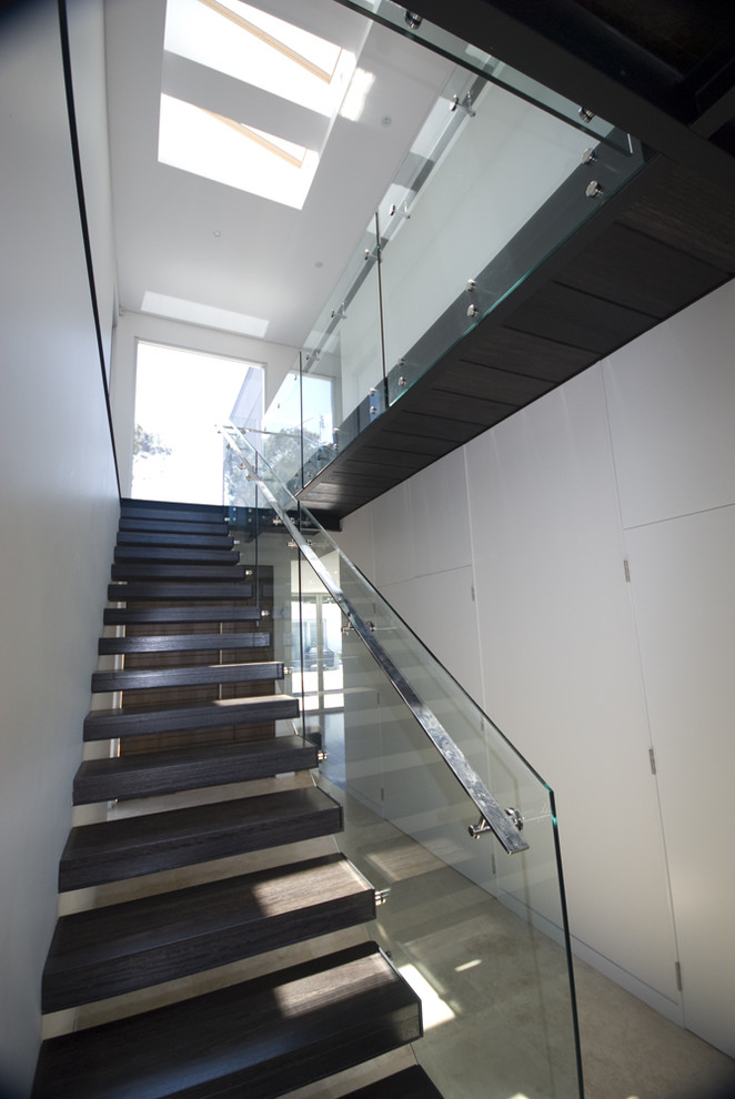 Cette photo montre un escalier sans contremarche flottant moderne avec un garde-corps en verre.
