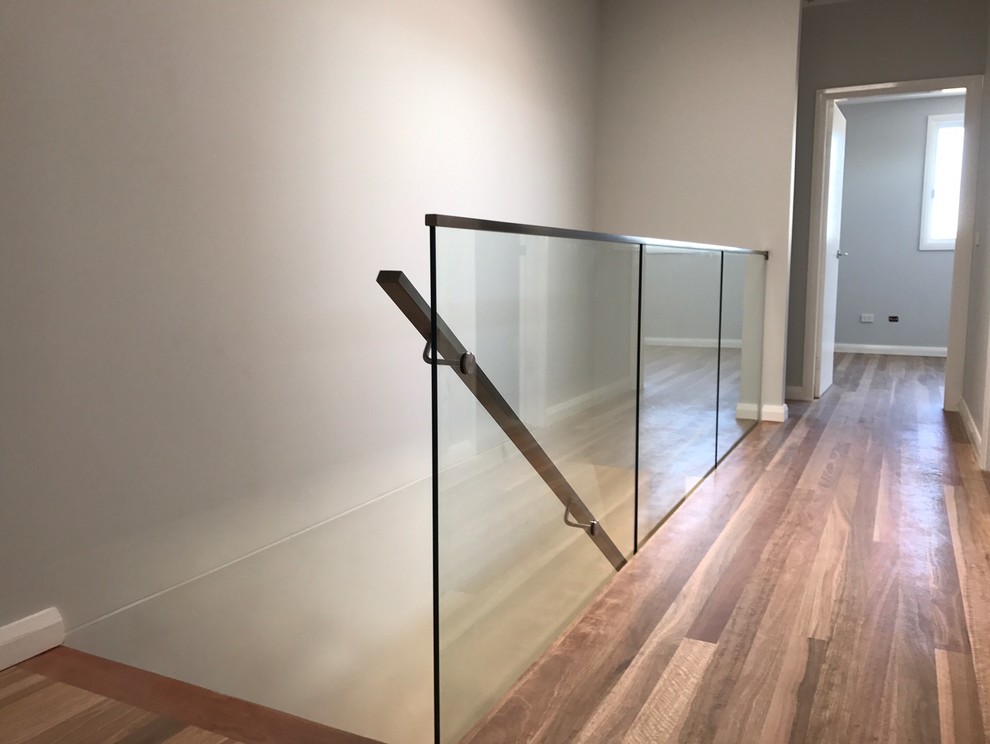 Foto di una scala sospesa contemporanea di medie dimensioni con pedata in legno, nessuna alzata e parapetto in vetro