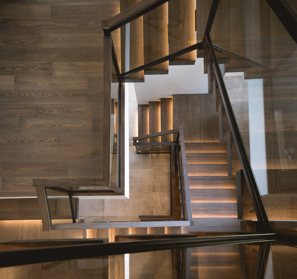 Ejemplo de escalera en L moderna de tamaño medio sin contrahuella con escalones de madera y barandilla de madera