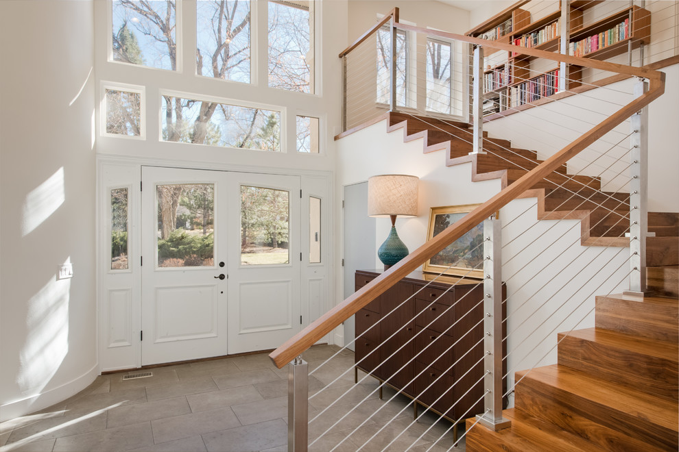 Inspiration pour un grand escalier minimaliste en L avec des marches en bois, des contremarches en bois, un garde-corps en câble et éclairage.