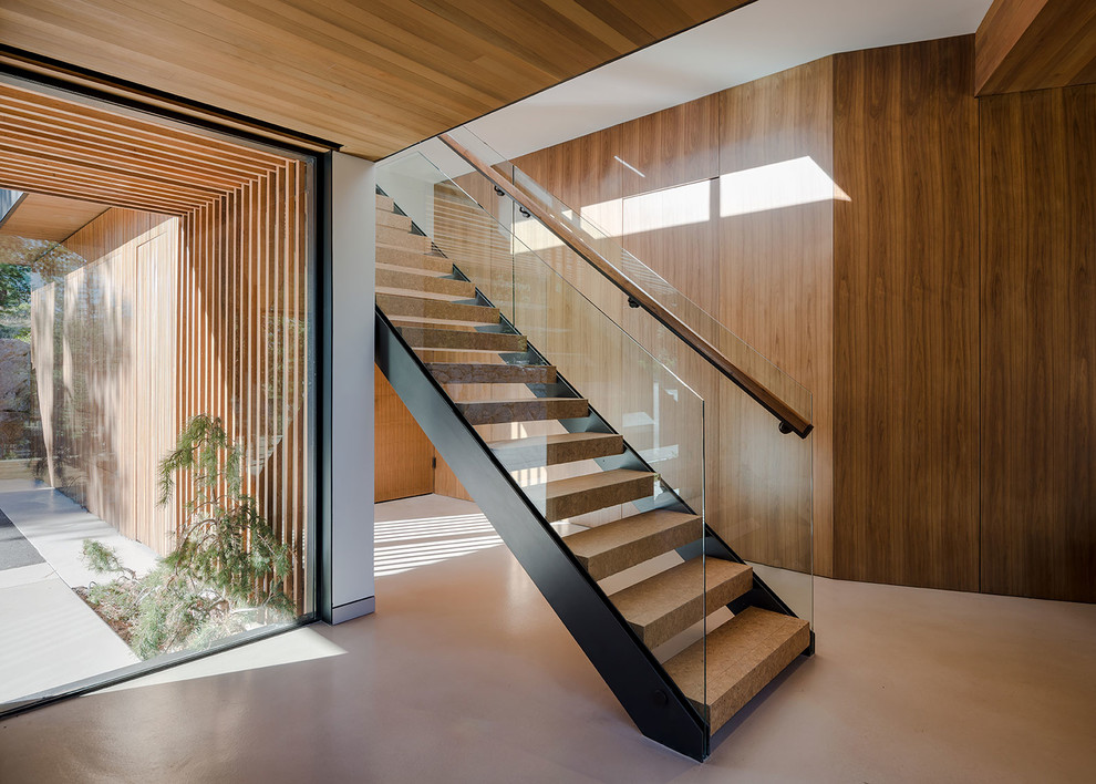 Imagen de escalera recta moderna de tamaño medio sin contrahuella con escalones de madera y barandilla de vidrio