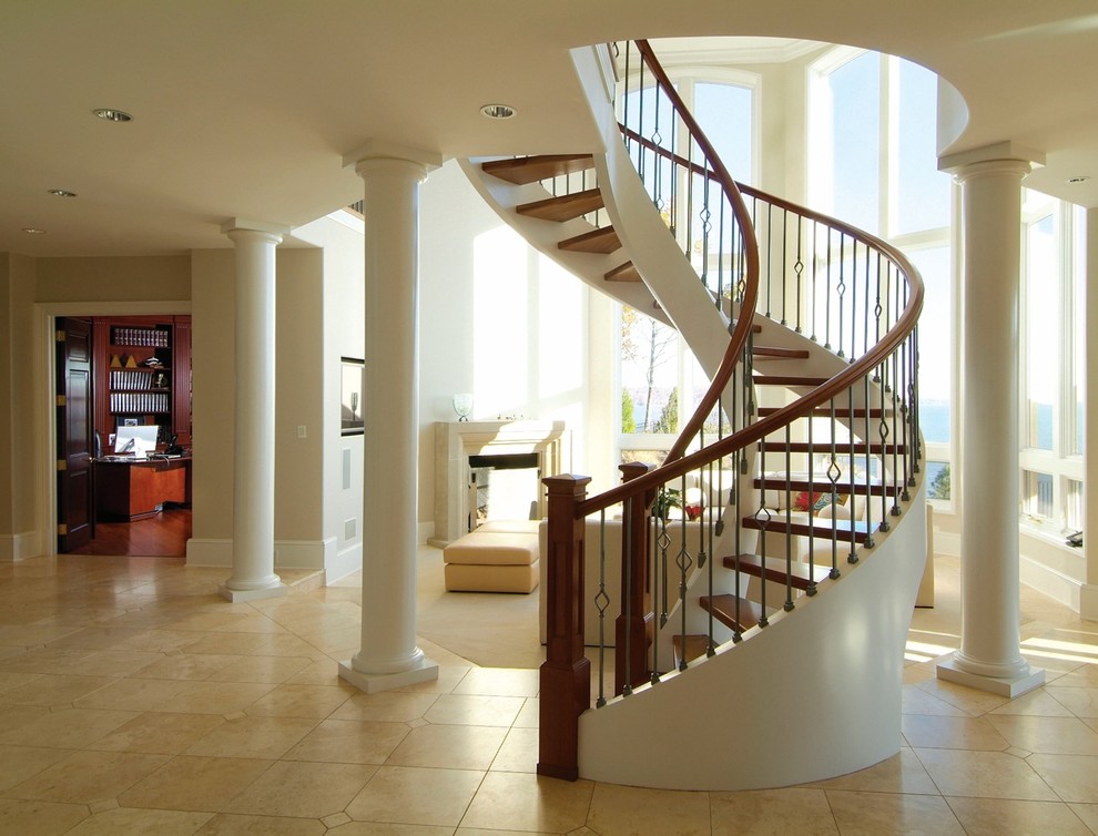 Exemple d'un grand escalier sans contremarche courbe chic avec des marches en bois et un garde-corps en matériaux mixtes.