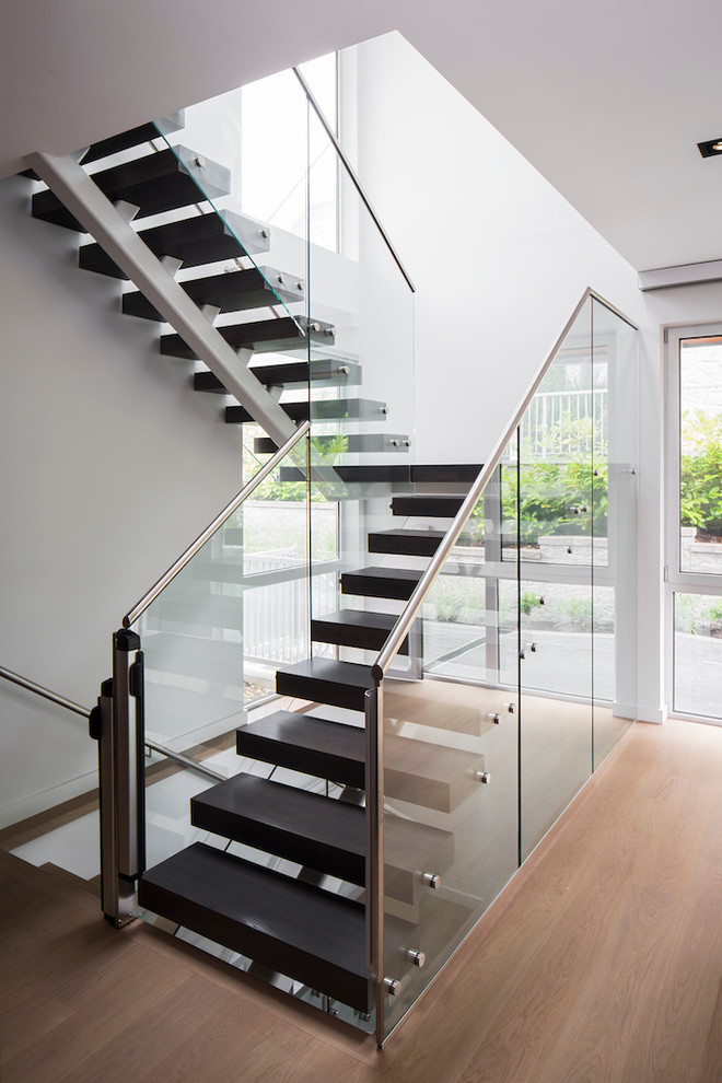 Cette photo montre un grand escalier tendance en L avec des marches en bois, des contremarches en métal et éclairage.