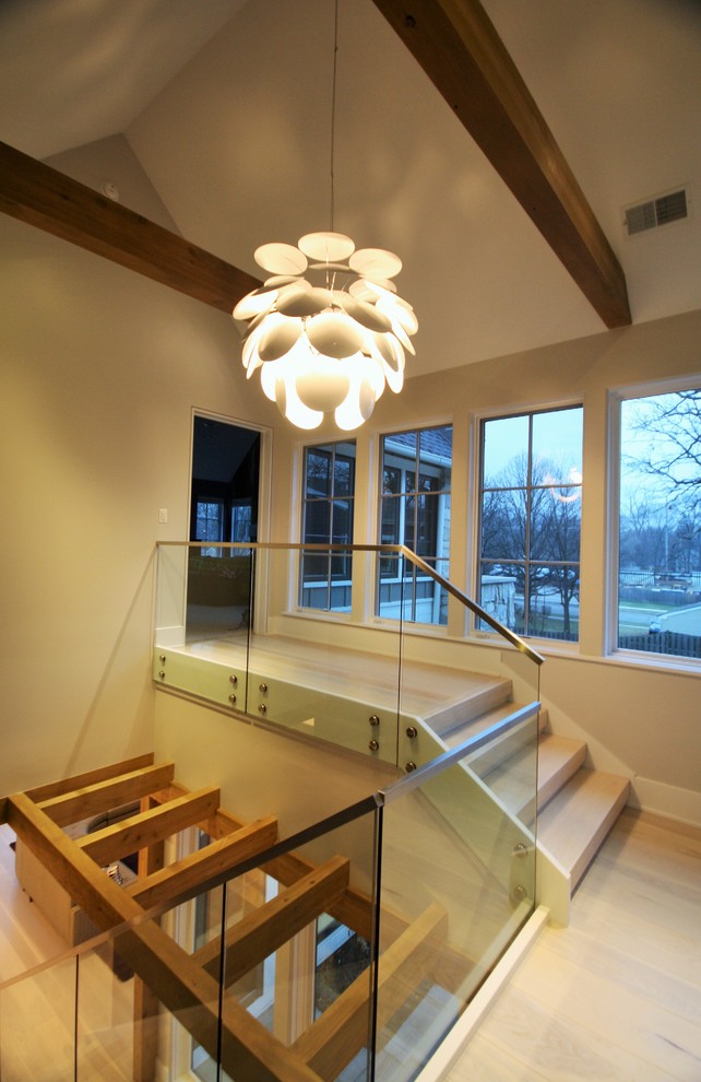 Imagen de escalera recta actual grande sin contrahuella con escalones de madera y barandilla de vidrio
