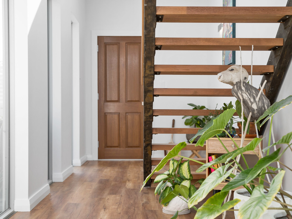Diseño de escalera recta actual pequeña con escalones de madera, contrahuellas de metal y barandilla de metal