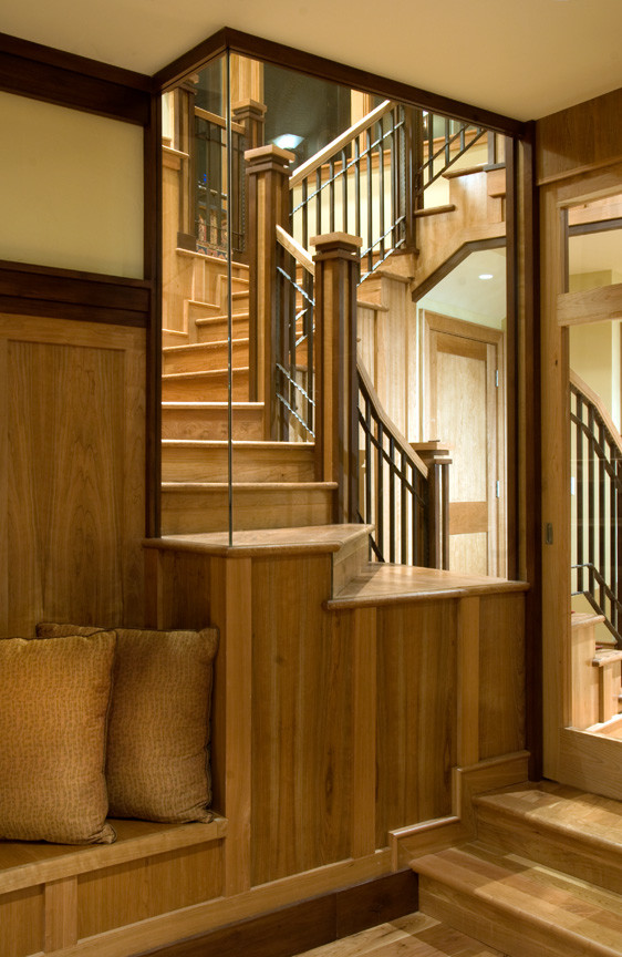 Ejemplo de escalera curva de estilo americano de tamaño medio con escalones de madera y contrahuellas de madera