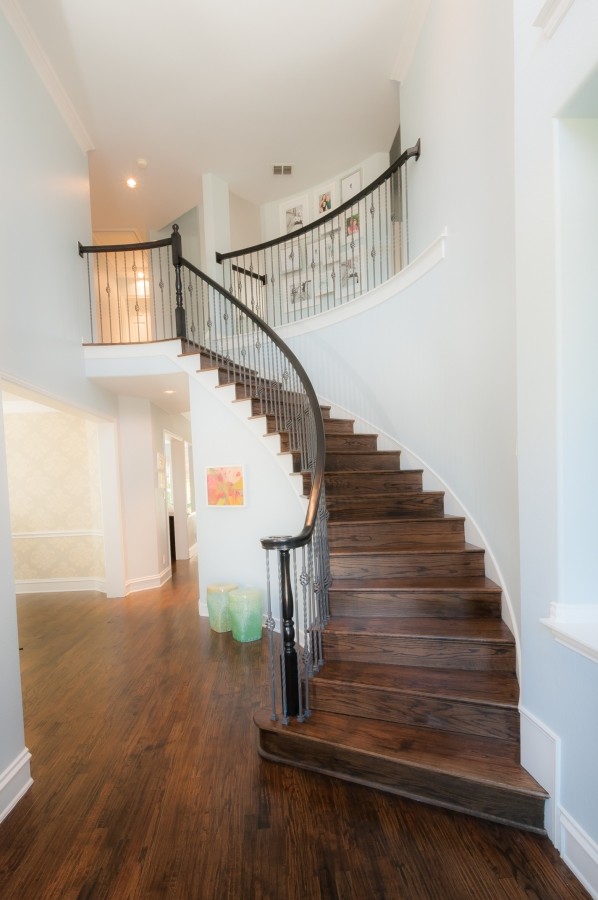 Ejemplo de escalera curva tradicional renovada de tamaño medio con escalones de madera y contrahuellas de madera