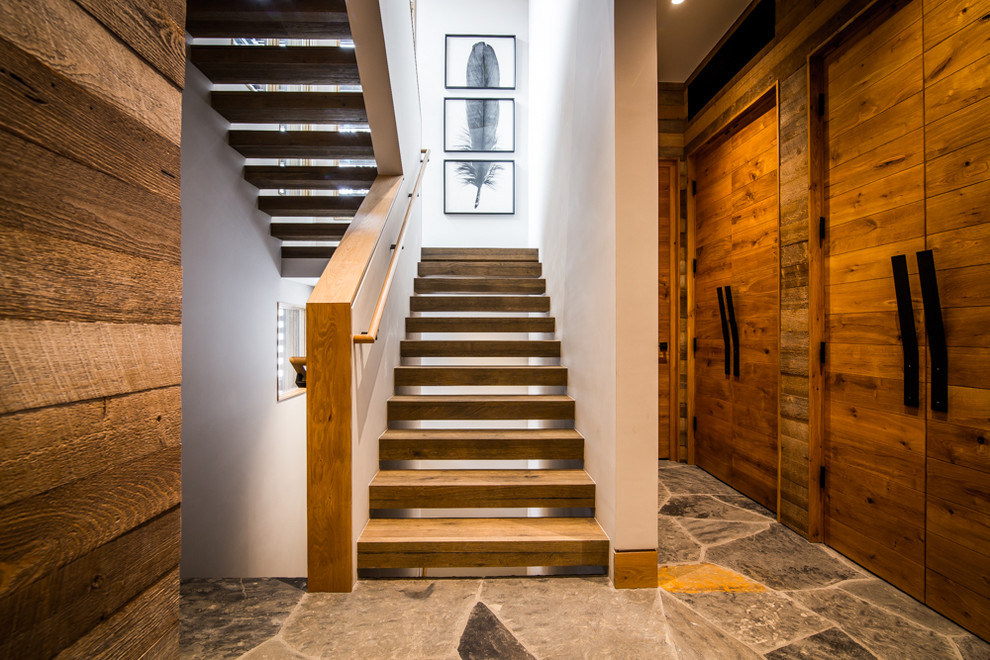 This is an example of a rustic wood u-shaped staircase in Denver with open risers.