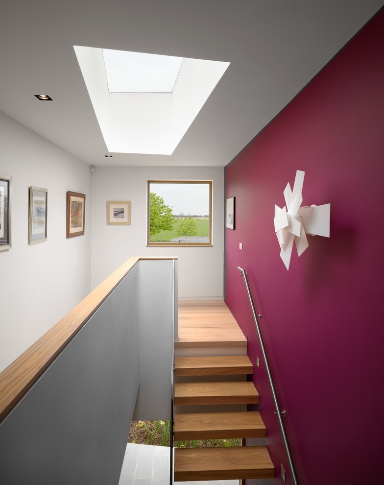 Design ideas for a contemporary wood floating staircase in London with open risers.