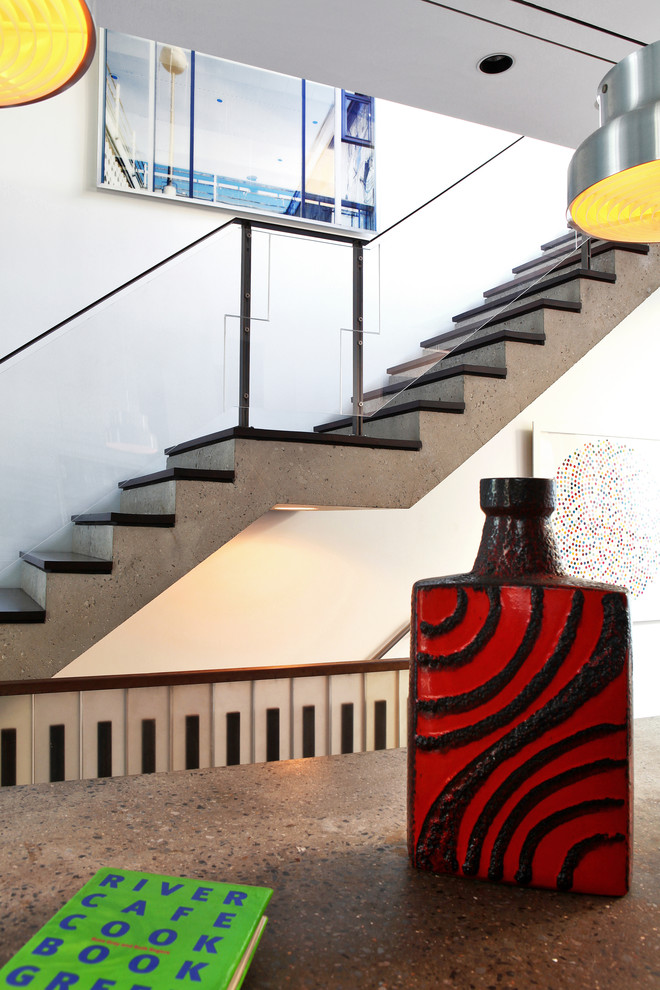 Cette photo montre un escalier droit moderne avec des marches en bois, un garde-corps en verre et éclairage.
