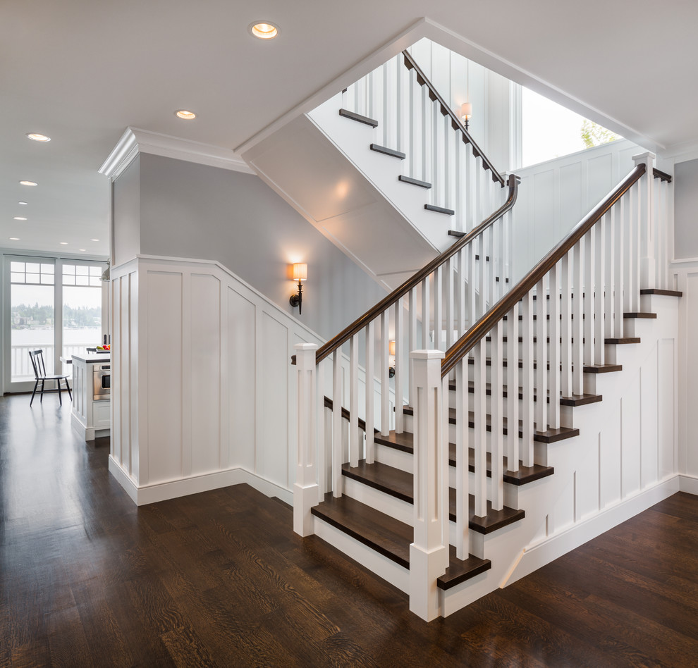 Ejemplo de escalera en U de estilo americano de tamaño medio con escalones de madera, contrahuellas de madera pintada y barandilla de madera
