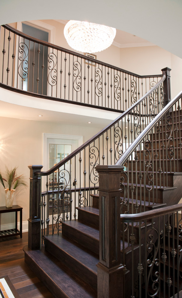 Exemple d'un grand escalier courbe chic avec des marches en bois et des contremarches en bois.