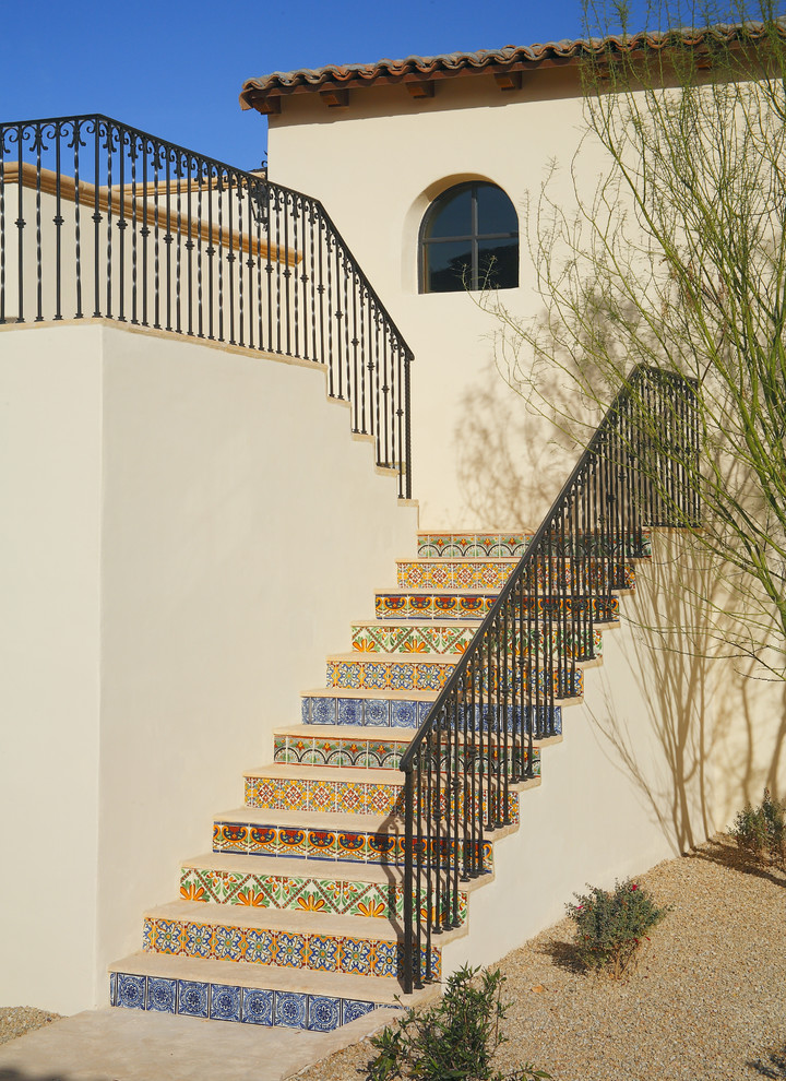 Imagen de escalera exterior mediterránea con escalones de madera y contrahuellas con baldosas y/o azulejos