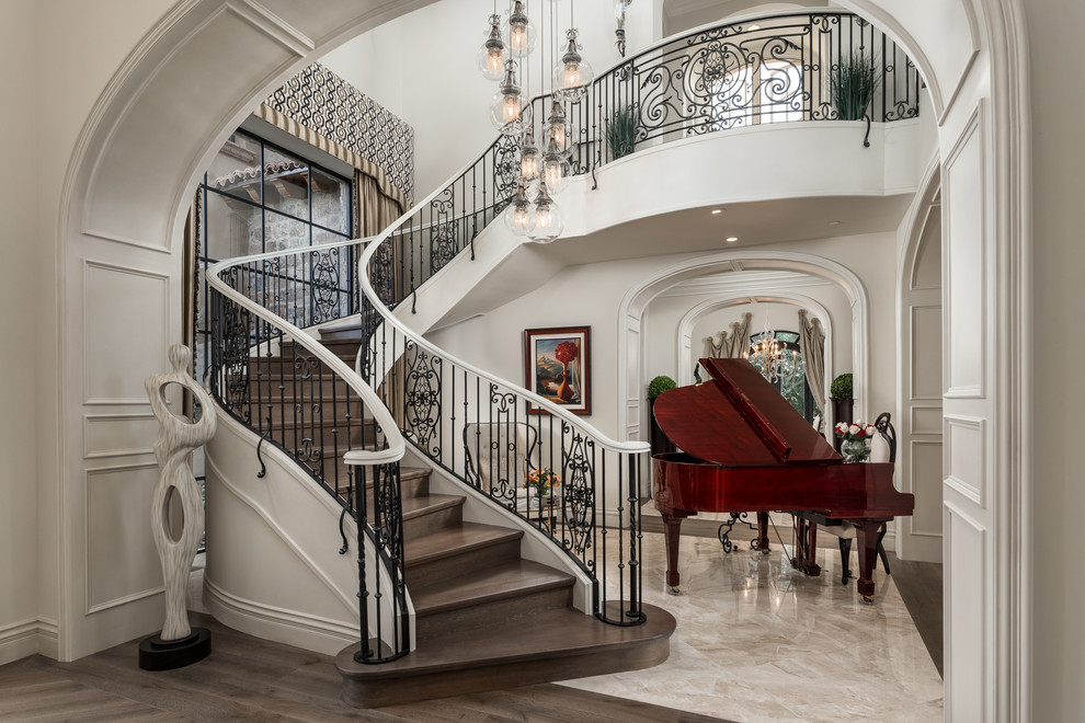 This is an example of a mediterranean wood curved mixed railing staircase in Phoenix with wood risers.