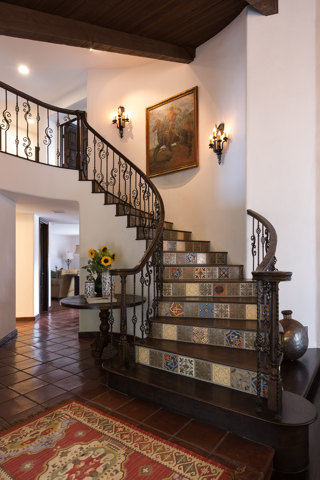 Foto de escalera curva mediterránea de tamaño medio con escalones de madera, contrahuellas con baldosas y/o azulejos y barandilla de varios materiales