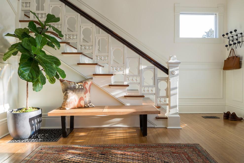 Imagen de escalera recta clásica renovada con escalones de madera, contrahuellas de madera pintada y barandilla de madera