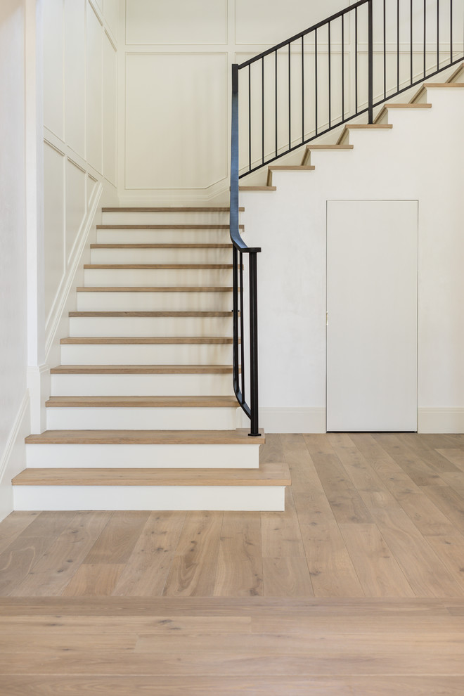 Cette image montre un escalier courbe design de taille moyenne avec des marches en métal et des contremarches en bois.