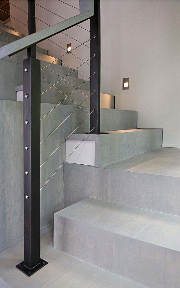 Idée de décoration pour un escalier minimaliste en L de taille moyenne avec des marches en bois, des contremarches en bois et un garde-corps en câble.