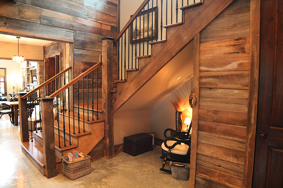 Large country wood u-shaped staircase in Houston with wood risers.