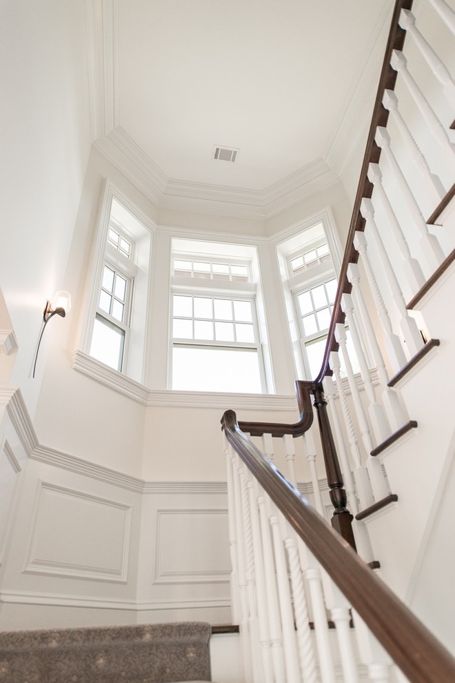 Inspiration for a large timeless wooden u-shaped staircase remodel in New York with wooden risers